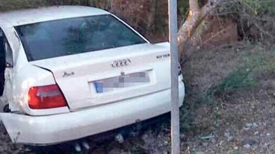 Un bombero de Mallorca, junto al Audi A4 siniestrado tras estrellarse contra un árbol.