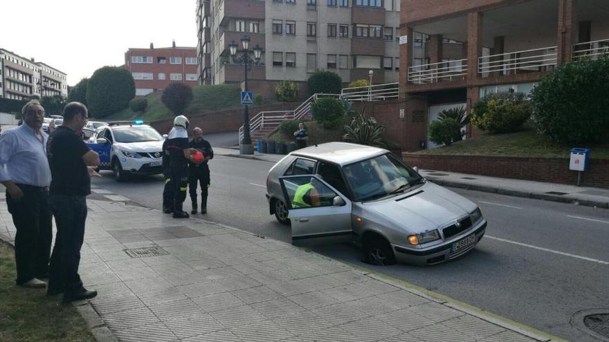 Los bomberos liberan a un coche que quedó atrapado por un socavón en Colloto