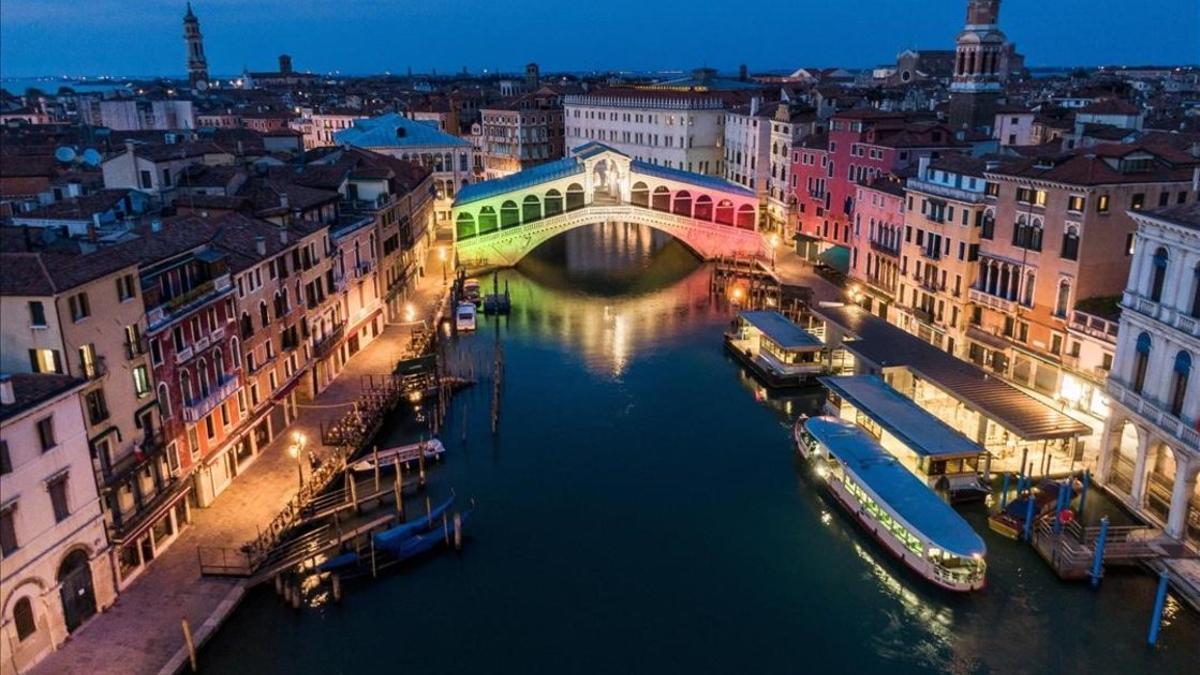 El puente de Rialto, sobre el Gran Canal, iluminado con los colores de la bandera italiana