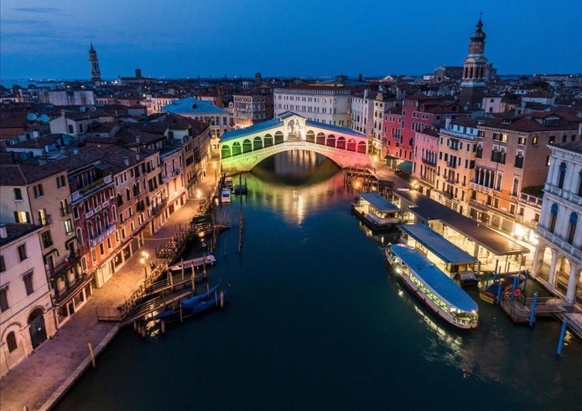 El puente de Rialto, sobre el Gran Canal, iluminado con los colores de la bandera italiana.