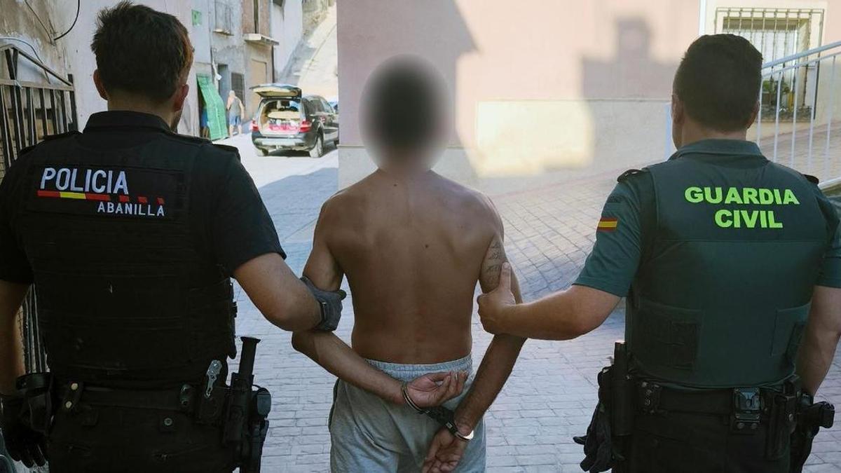 Un agente de la Policía Local de Abanilla y otro de la Guardia Civil custodian al sospechoso de los robos.