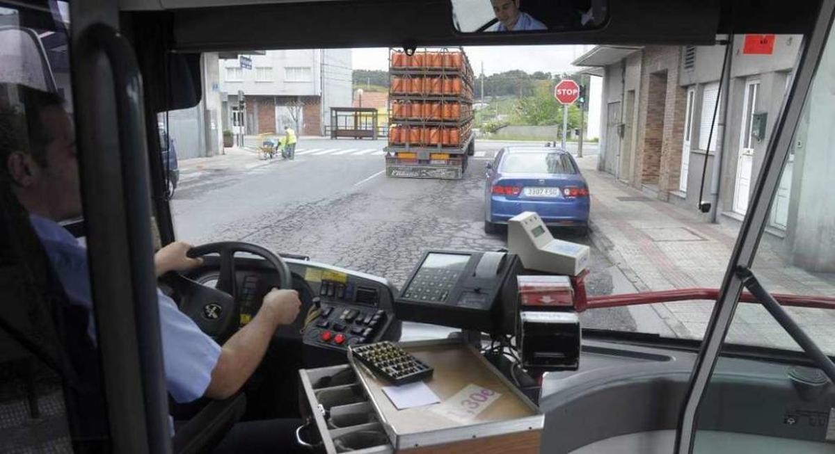 Interior de la parte delantera de un bus en la ciudad, con el precio pegado en el mostrador.