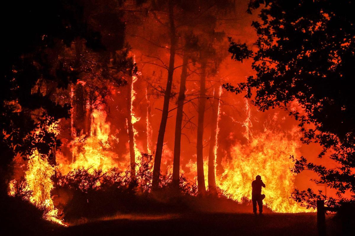 Una silueta se dibuja en frente de las llamas en un incendio cerca de Belin-Beliet, en el suroeste de Francia, la madrugada del 11 de agosto del 2022.