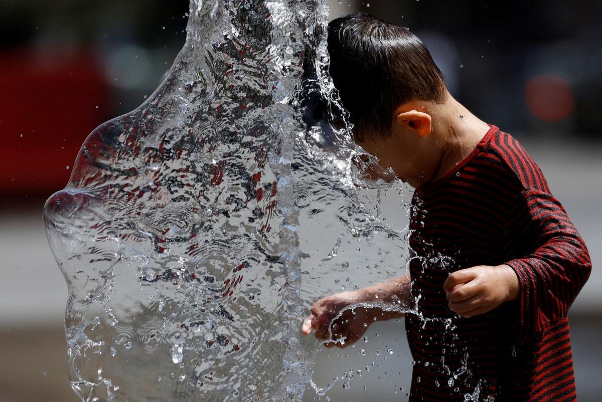Un niño juega con una fuente en Bruselas, en plena ola de calor.
