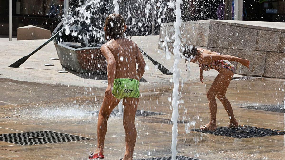 Unos niños se refrescan en Santa Eulària el viernes.