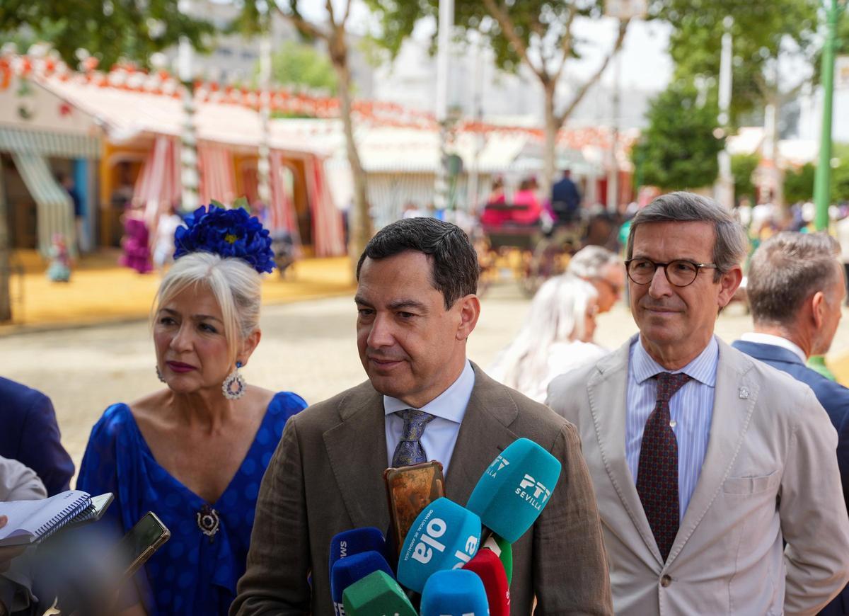 El presidente de la Junta de Andalucía, Juanma Moreno (c), junto a la consejera de Cultura, Patricia del Pozo, y el consejero de Industria,Jorge Paradela (d), atienden a los medios a su llegada a la Feria de Abril. A 22 de abril de 2026, en Sevilla