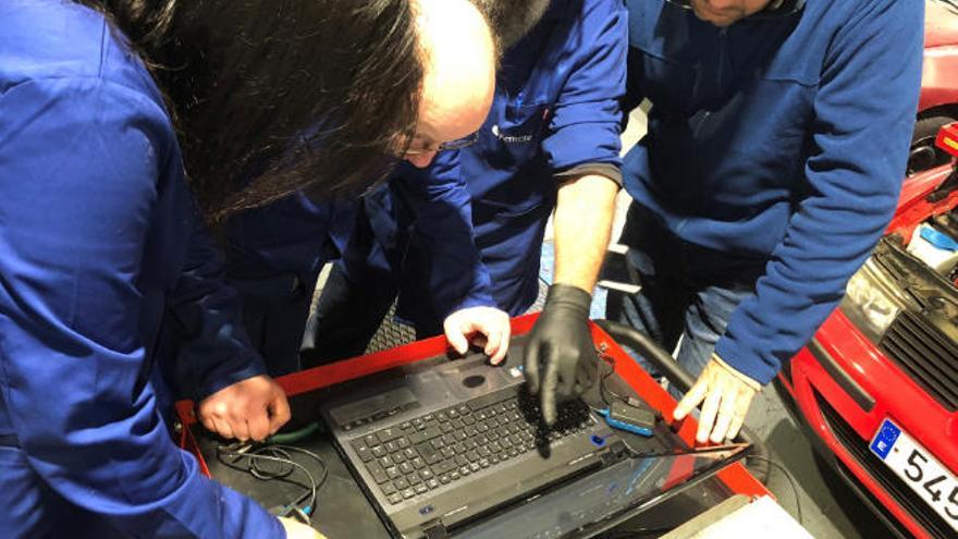 Un grupo de mecánicos repara un vehículo en un taller de Tenerife.
