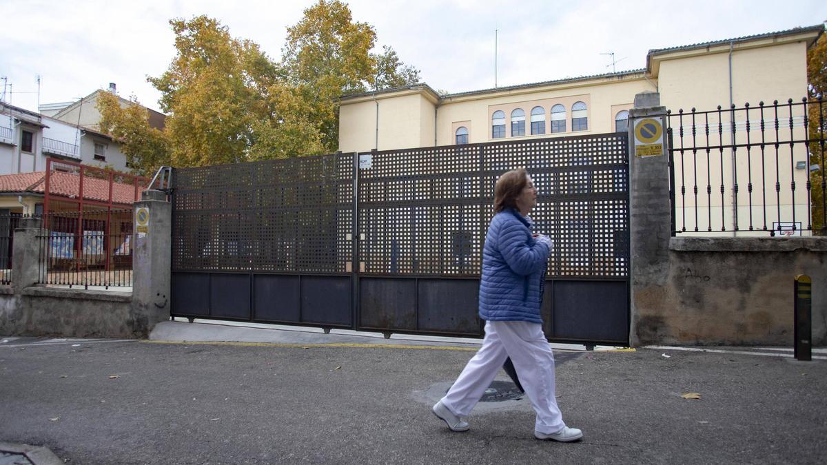 Una mujer pasea por delante de la puerta metálica que se desplomó.