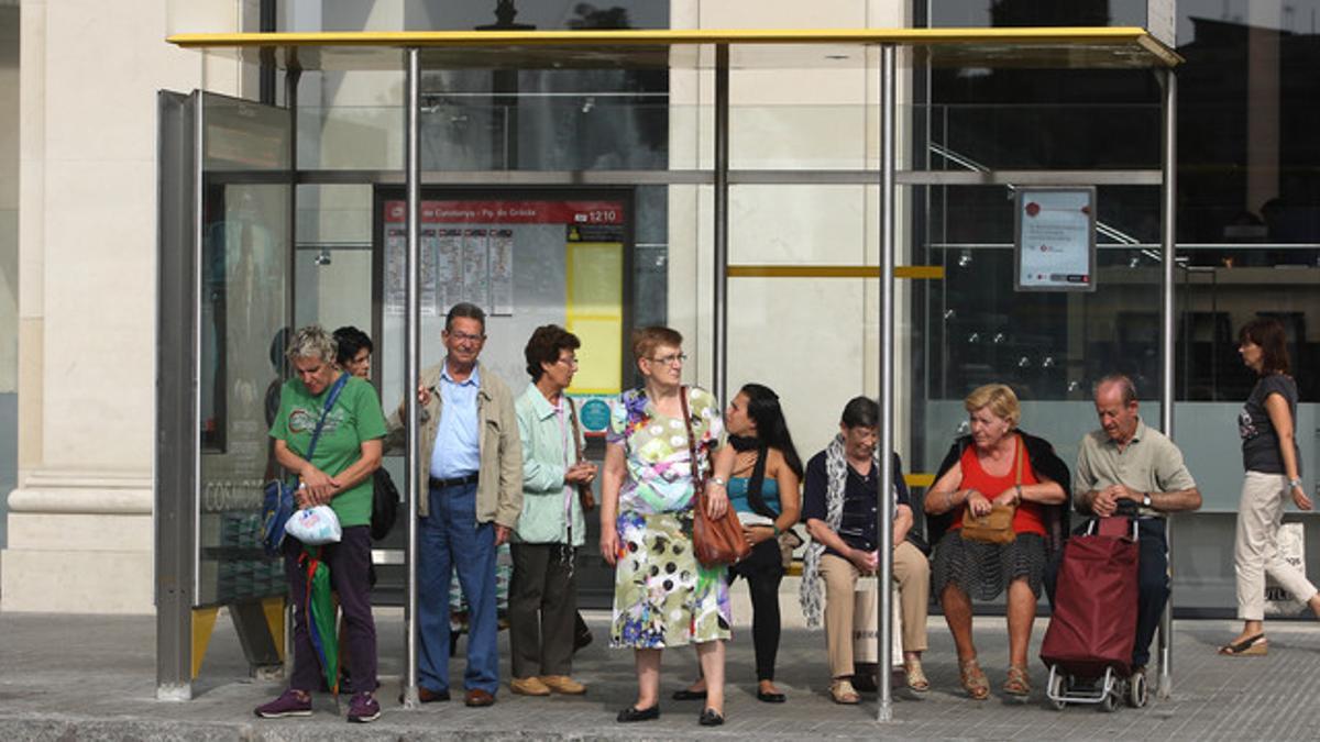 Pasajeros en una parada de autobús de la plaza de Catalunya, de Barcelona, en un día de huelga del servicio, el pasado octubre.