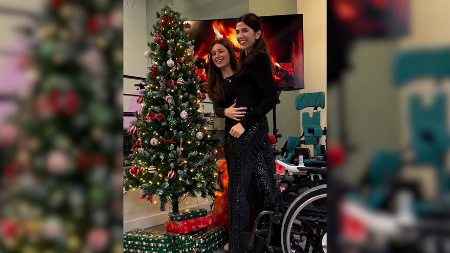 Virginie Dubost, en silla de ruedas desde 2018, consigue ponerse de pie para colocar un adorno en el árbol de Navidad