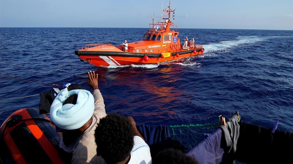 Inmigrantes hacen señas al barco de rescate de la oenegé Proactiva Open Arms, en el mar Mediterráneo, el 8 de agosto del 2018.