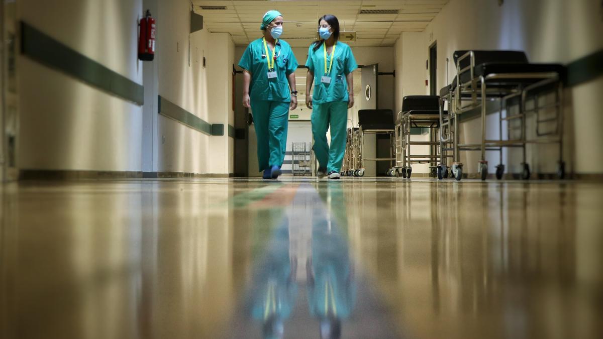Dos profesionales sanitarias caminan por los pasillos de un centro hospitalario.