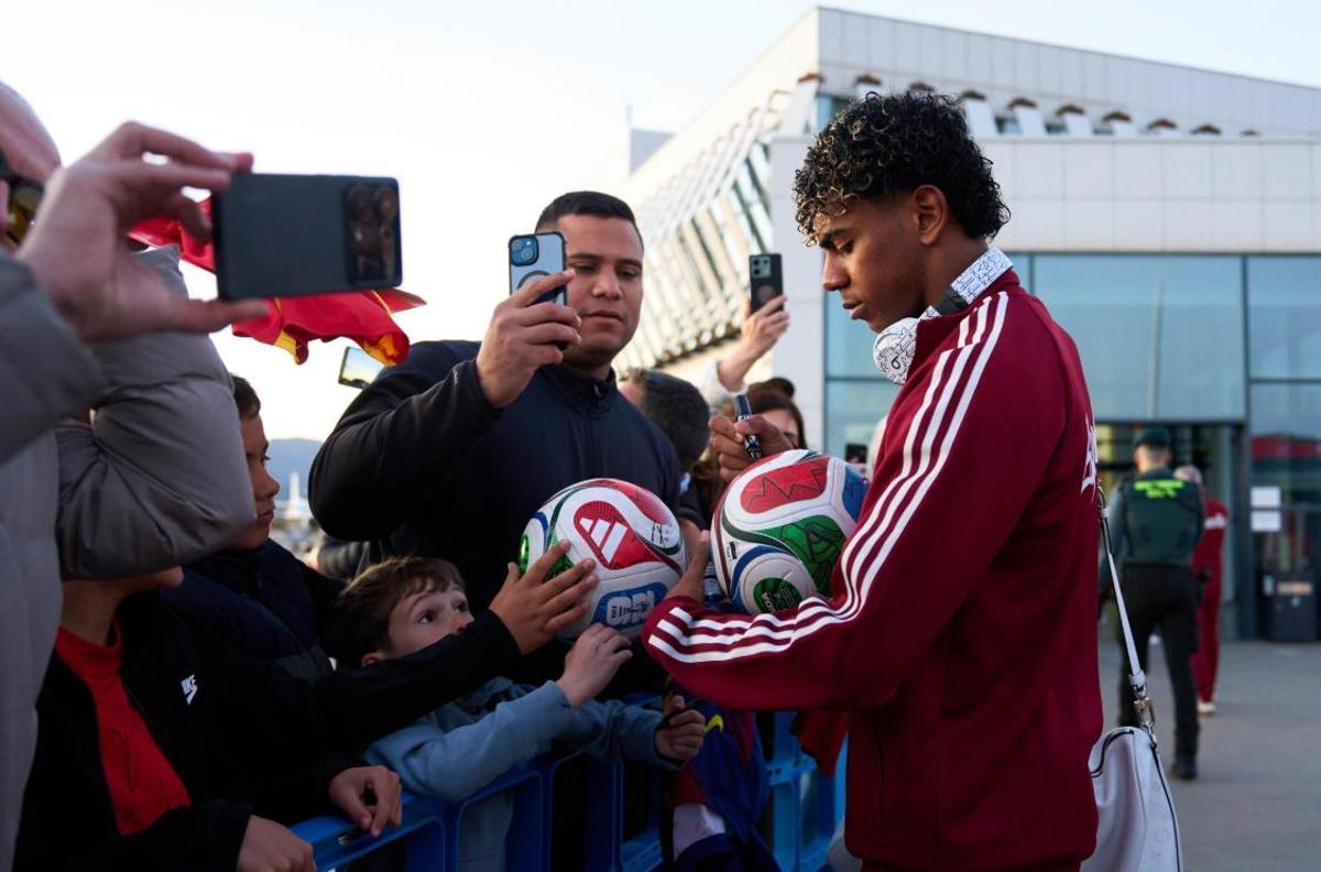 Lamine firma autógrafos en el viaje a Barcelona con la selección.
