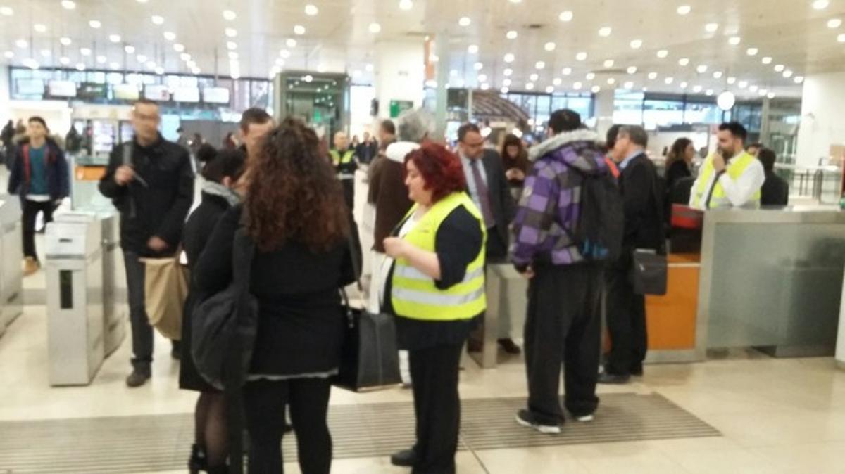 Una trabajadora de Rodalies Renfe da explicaciones a los usuarios, en la estación de Sants.