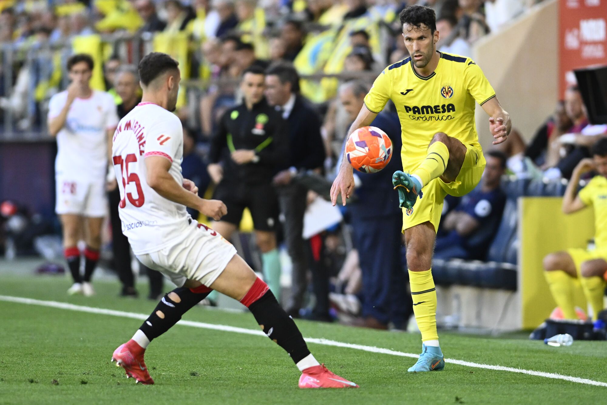 VILLARREAL (CASTELLÓN), 25/05/2025.- El defensa del Villarreal Alfonso Pedraza (d) pelea un balón ante el defensa del Sevilla Ramón Martínez Gil este domingo, durante el partido de la jornada 38 de LaLiga EA Sports, que Villarreal y Sevilla disputan en el Estadio de la Cerámica. EFE/ Andreu Esteban