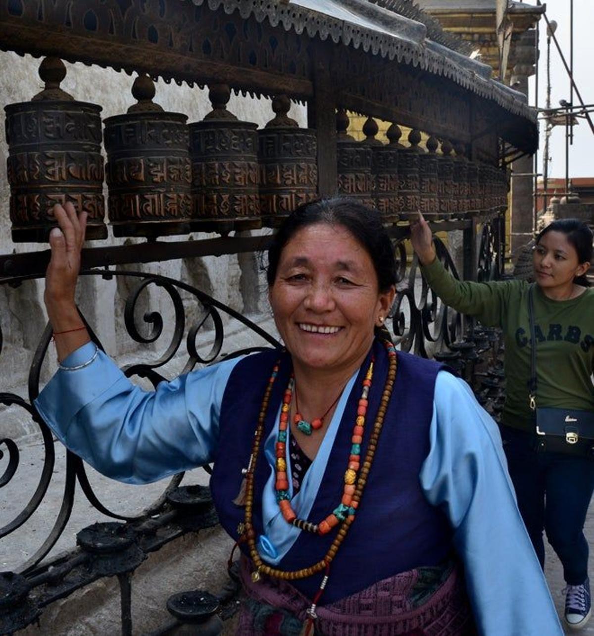 Una mujer gira los molinillos de oración de Swayanbhunath.