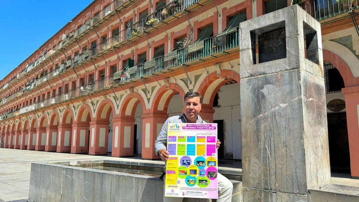 Miguel ruiz Madruga muestra el cartel con la programación de  ‘En Córdoba, verano participa'.