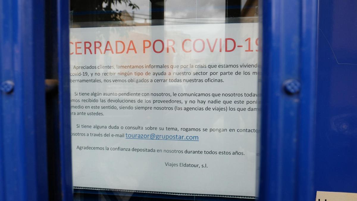 Cartel colocado en el escaparate de una agencia de viajes de Elda.