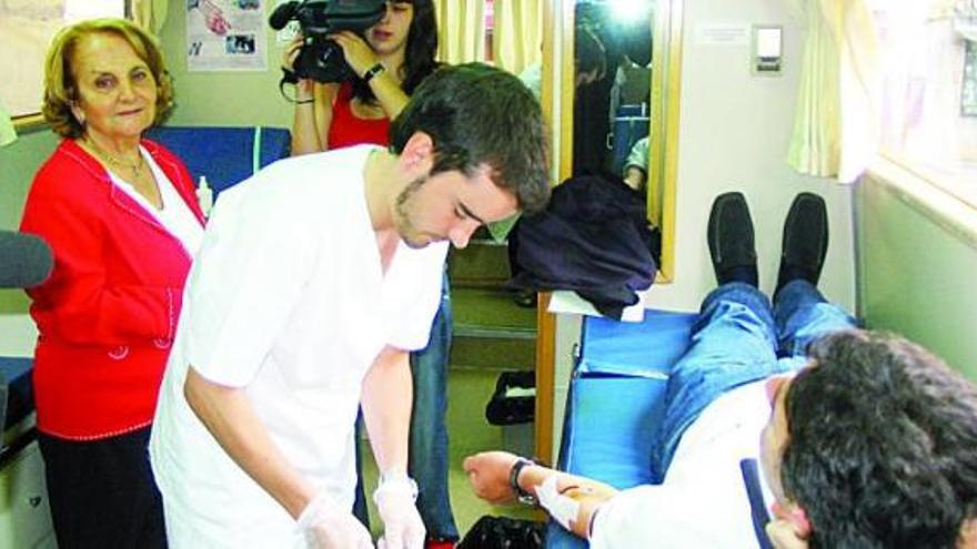 Paz Fernández Felgueroso, a la izquierda, observa una donación de sangre en la unidad móvil instalada en la plaza Mayor de Gijón.