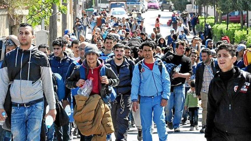 Un grup de refugiats caminen pels carrers de la població de Quios