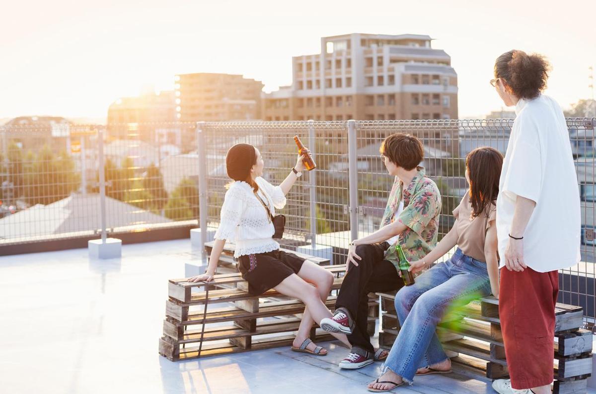 Grupo de jóvenes sentados en una azotea en un entorno urbano