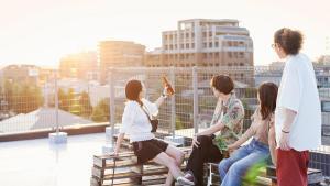 Grupo de jóvenes sentados en una azotea en un entorno urbano