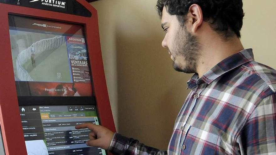 Un joven realiza una apuesta en una terminal de un bar.