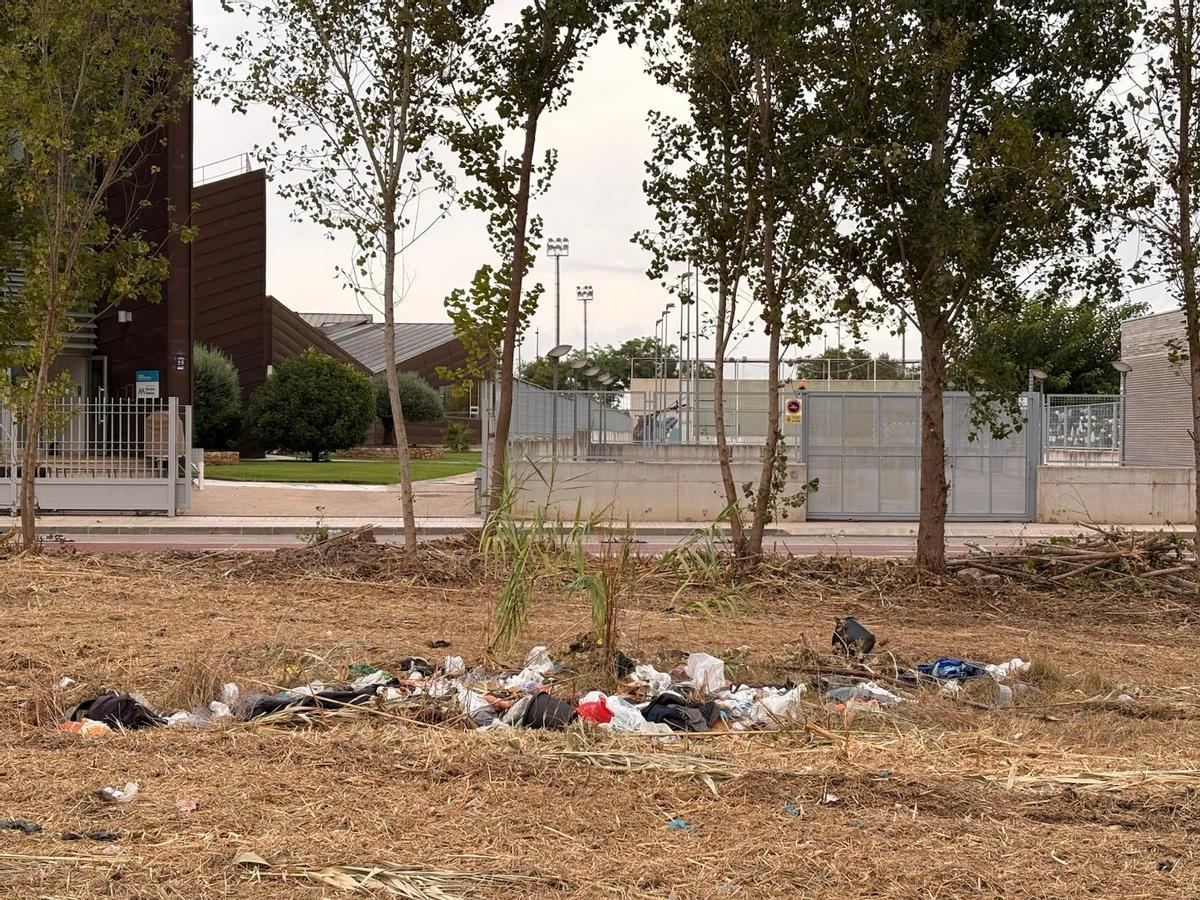 Bolsas con ropa y residuos encontradas entre la maleza en solares junto a los centros educativos.