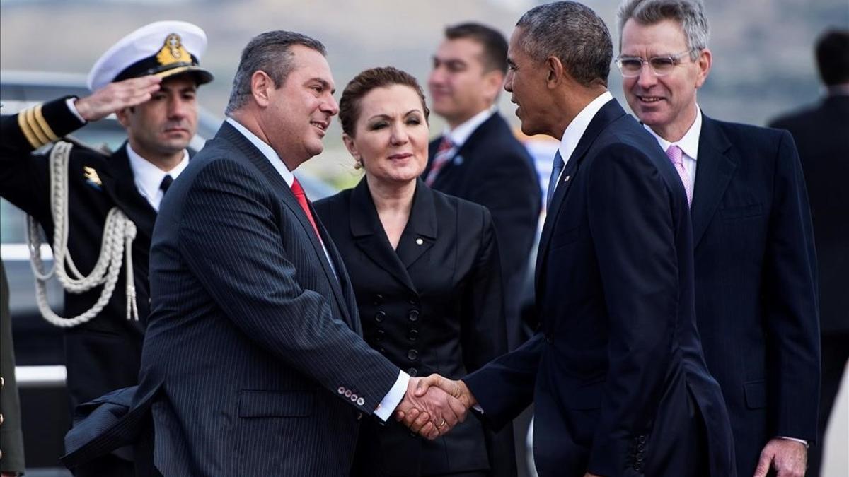 Obama es recibido por el ministro griego de Defensa, Panagiotis Kommenos.