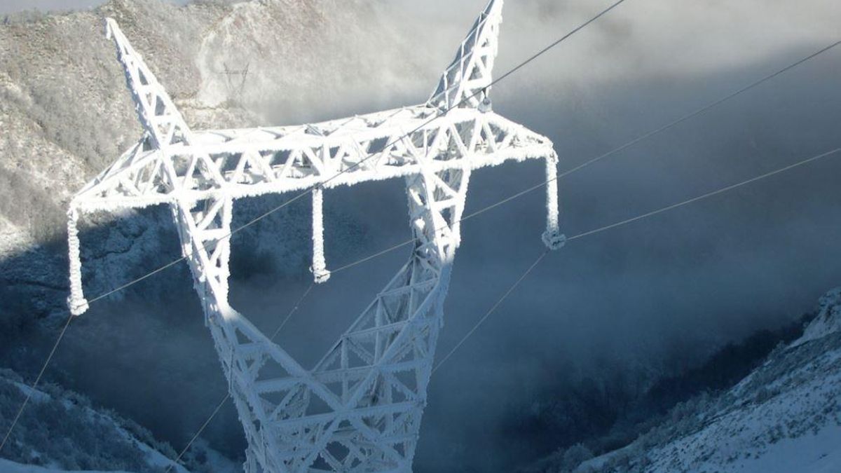 Torre de la red de electricidad completamente cubierta de hielo.