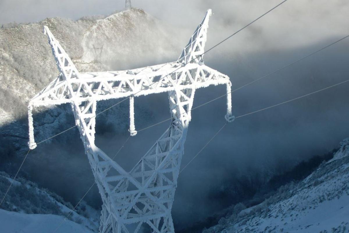 Torre de la red de electricidad completamente cubierta de hielo.