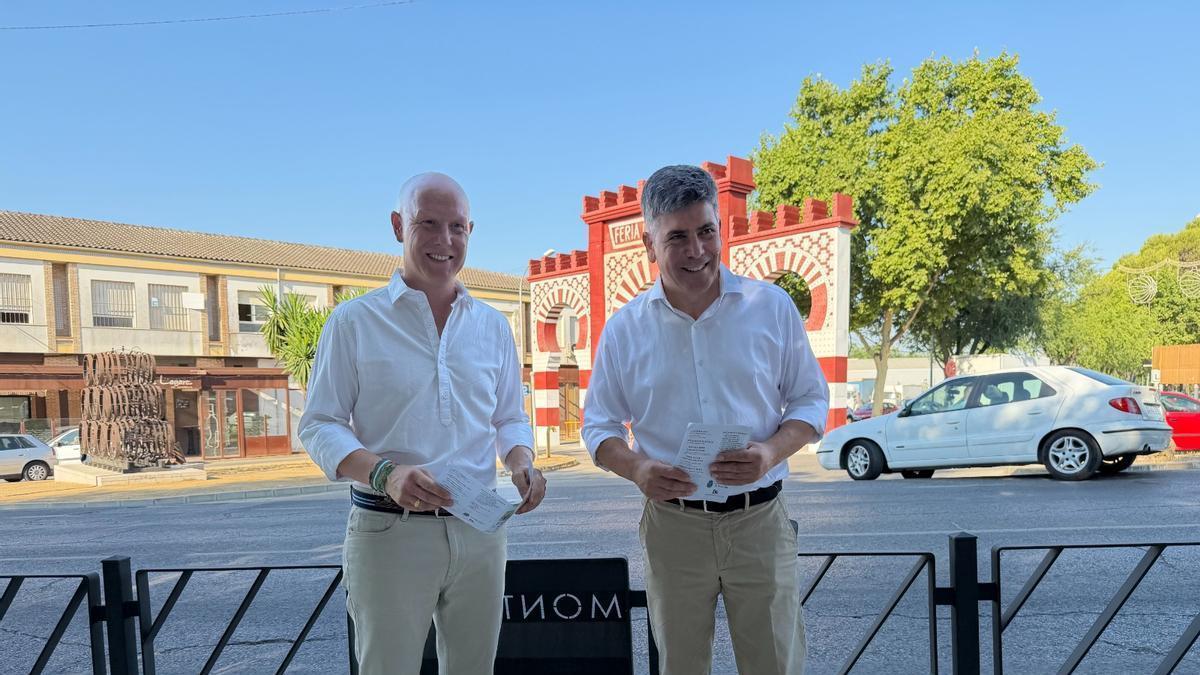 Miguel Sánchez y Rafael Llamas, ante la portada de feria que evoca los desaparecidos Arcos de la Puerta de Aguilar.