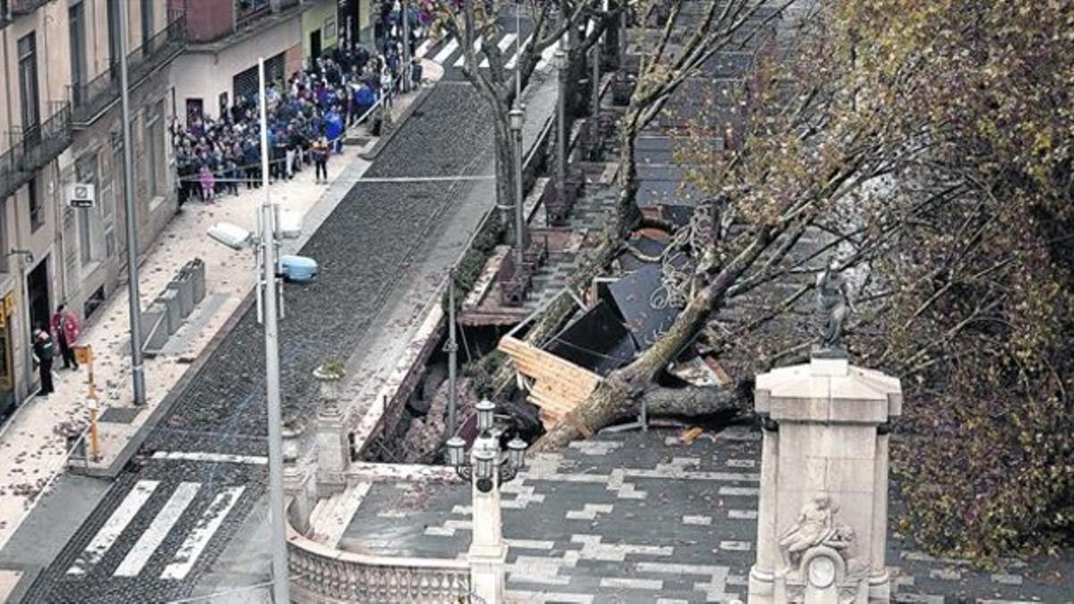 Un grupo de vecinos observa el socavón abierto en la Rambla de Figueres, ayer.