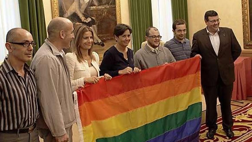 Despliegue de bandera en el Ayuntamiento, con Eva Illán, Carmen Moriyón y Santiago Martínez Argüelles como representación municipal.