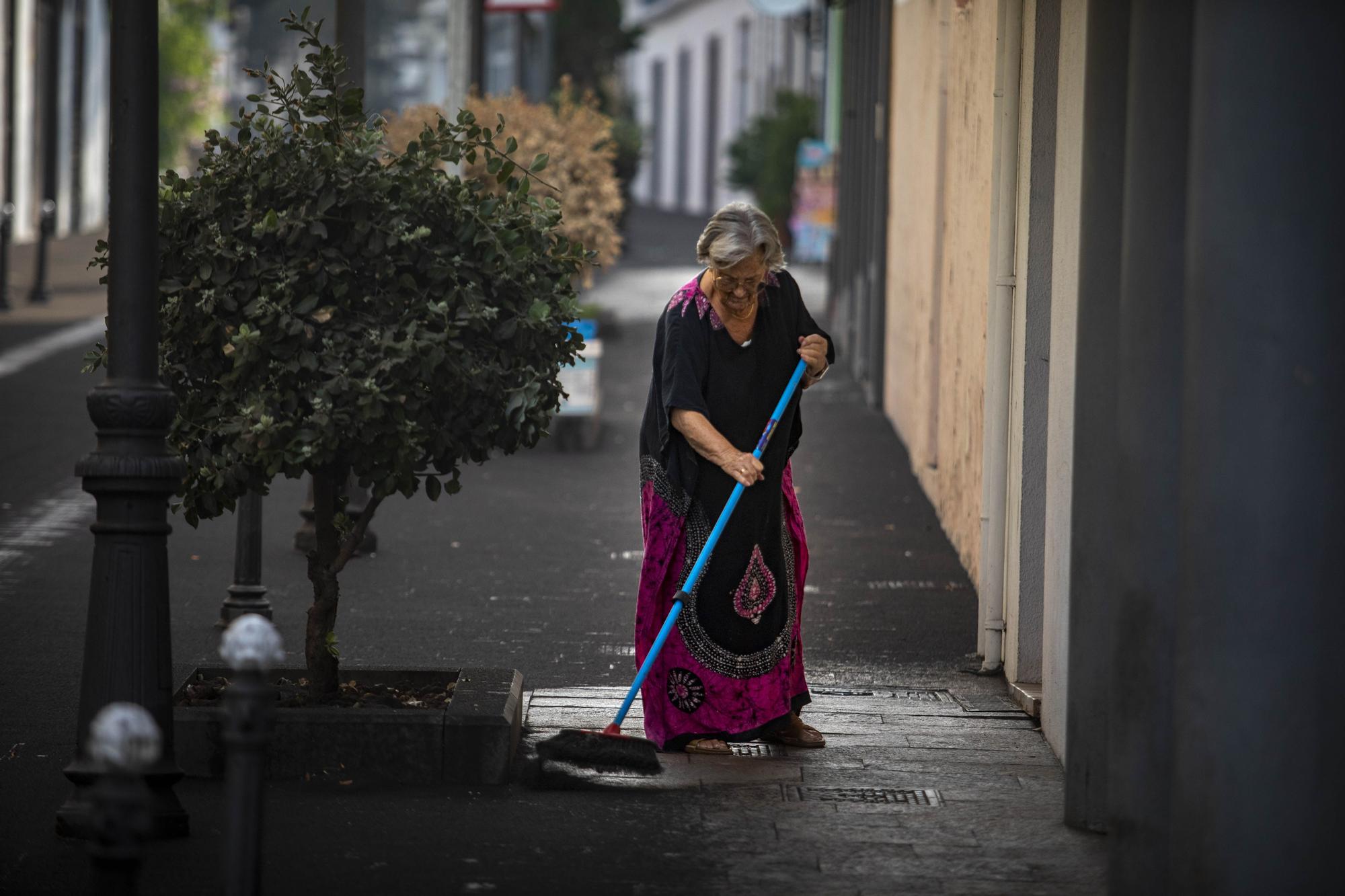 Una mujer barre la ceniza que ha llovido en Los Llanos de Aridane, a 1 de octubre de 2021, en Los Llanos de Aridane, La Palma.