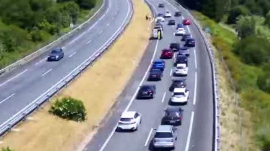 Retenciones en la AP-9 por un accidente, con el coche accidentado al fondo