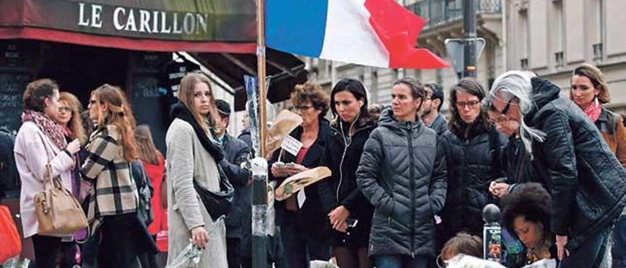 Parisinos rindiendo homenaje a las víctimas de los atentados terroristas.