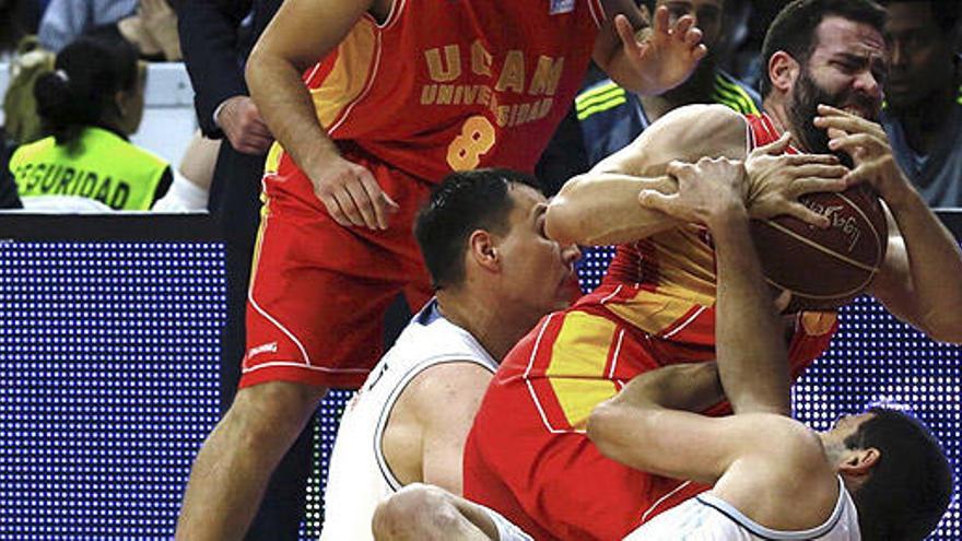 Cabezas lucha por el balón con Maciulis y Reyes.