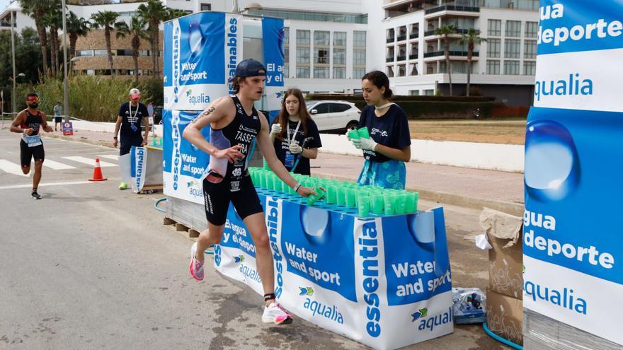 Dos corredores pasan por delante de un punto de avituallamiento de agua en el Mundial en Santa Eulària.