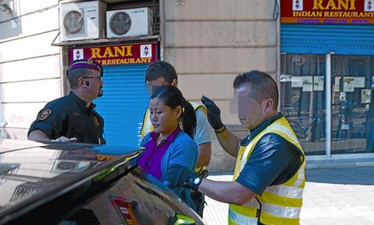 Los Mossos conducen a una de las arrestadas, ayer, en la calle de Bailèn.