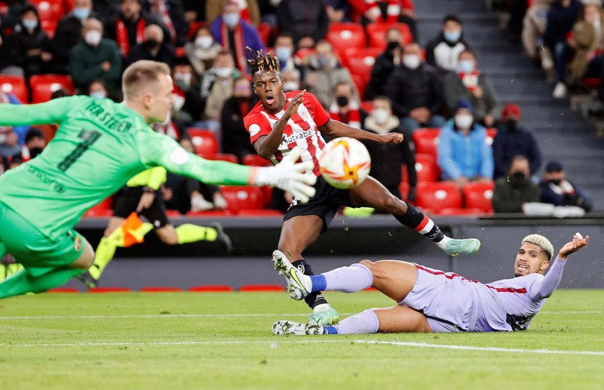 BILBAO, 20/01/2022.- El delantero del Athletic Club, Nico Williams (c), tras golpear el balón ante los jugadores del FC Barcelona, el guardameta alemán Marc-André ter Stegen (i) y el defensa uruguayo Ronald Araujo, durante el encuentro correspondiente a los octavos de final de la Copa del Rey que disputan hoy jueves en el estadio de San Mamés, en Bilbao. EFE / Luis Tejido.