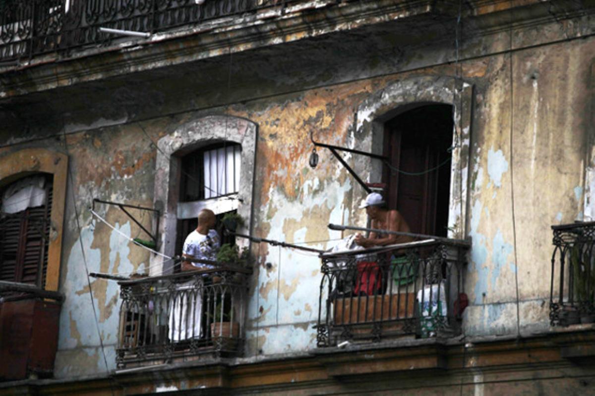 Dos homes observen el carrer des dels balcons de casa seva a l’Havana (Cuba).
