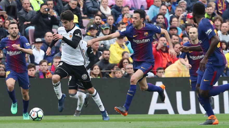 Carlos Soler se va por velocidad de Sergio Busquets en el Camp Nou.