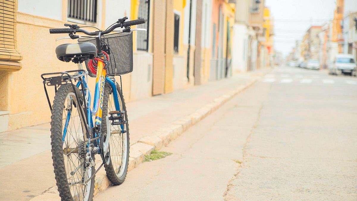 Una bicicleta aparcada junto a la acera de una de las calles de Càrcer.