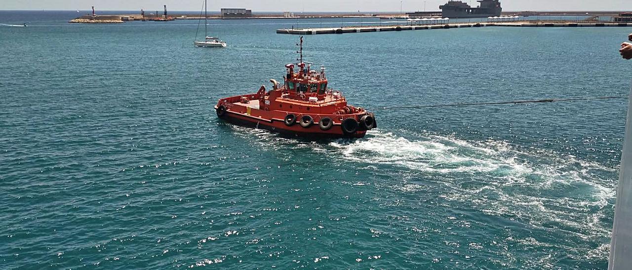 Una embarcación remolcando ayer al ferri de la Tras, a su salida del puerto palmesano.