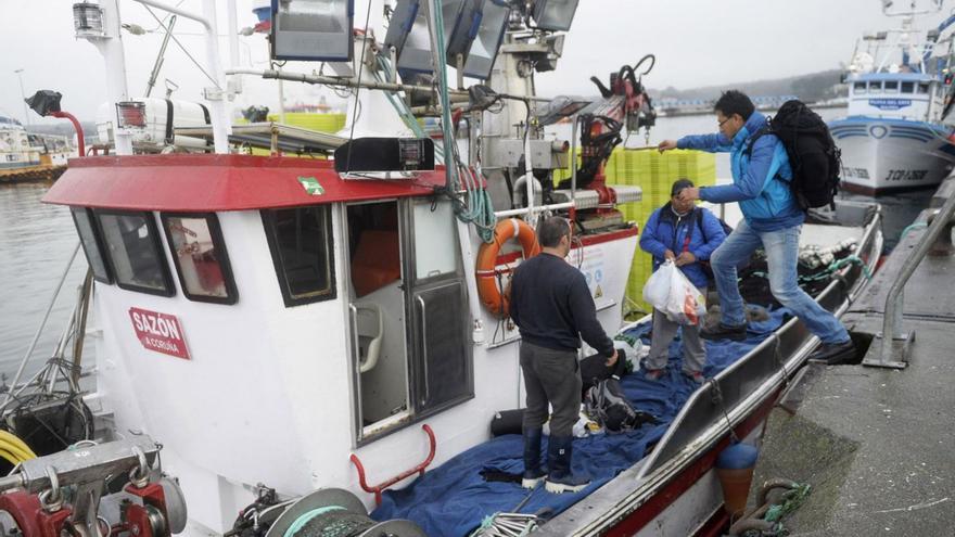 Un marinero sube a bordo de un barco pesquero en el puerto de A Coruña. |   // CARLOS PARDELLAS