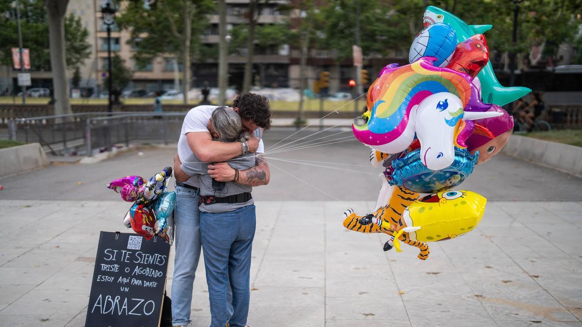 Una vendedora de globos abraza a Alexandre.