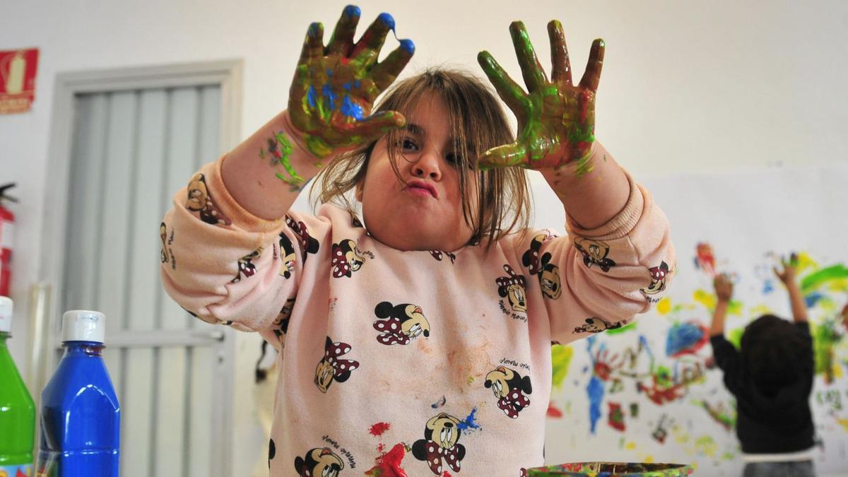 Una niña del colegio Alcudia de Elche muestra sus manos llenas de pintura, en uno de los talleres sobre el desarrollo de la psicomotricidad del proyecto Erasmus. | MATÍAS SEGARRA