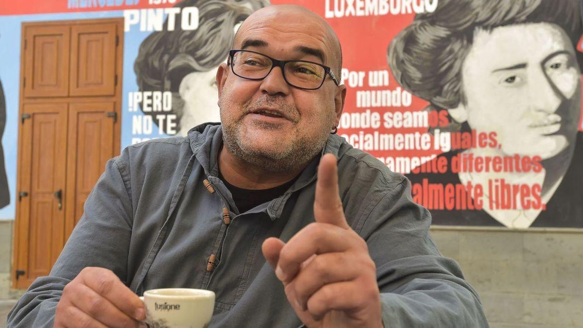 l escritor Alexis Ravelo en una plaza de Las Palmas de Gran Canaria, detrás, el mural feminista con la imagen de Rosa Luxemburgo y Mercedes Pinto.