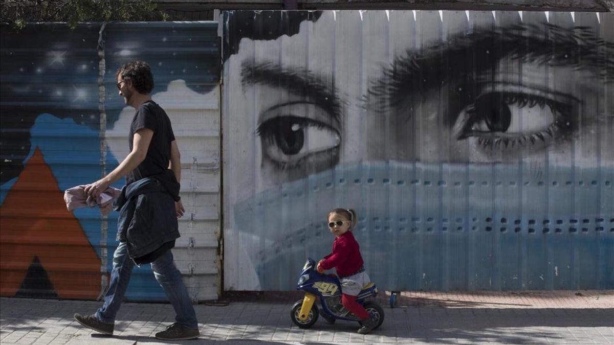 coronavirus. Grafiti de una mujer con mascarilla en una calle del barrio de la Bonanova, en Barcelona